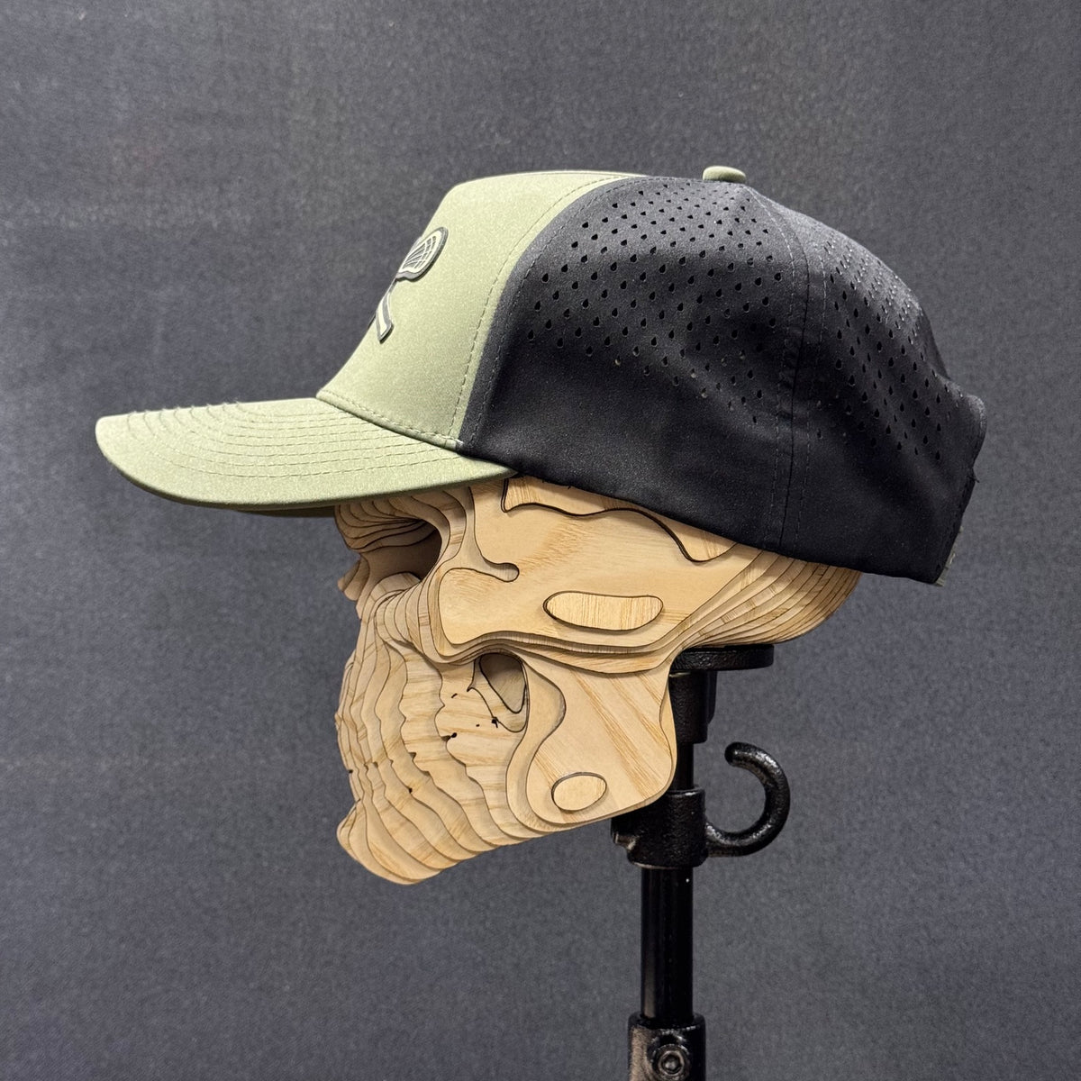 Opposite side profile showing the curved loden brim and perforated black panels.